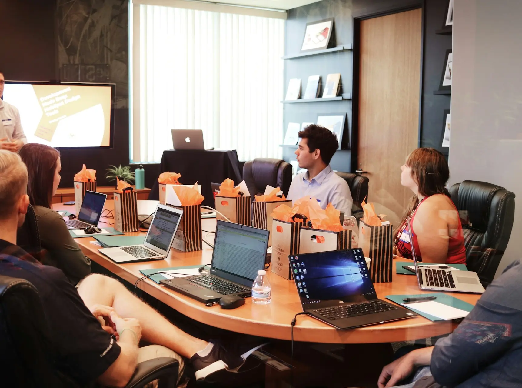man standing in front of people sitting beside table with laptop computers